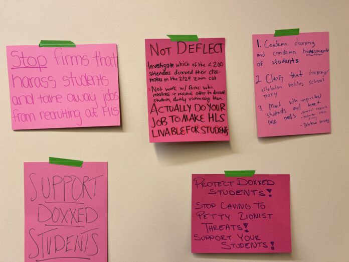 Five different posters on the wall levying criticism at the administration for failing to protect doxxed students from retaliation or professional harm. Posters were hung in front of the Dean of Students office by protestors.