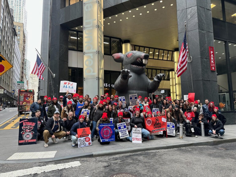 Mobilization for Justice (MFJ) workers picketting in front of the MFJ office in New York, NY. A large inflatable rat, a regular sight at picketting events, is displayed behhind the workers. (Miriam Shestack, 2024)