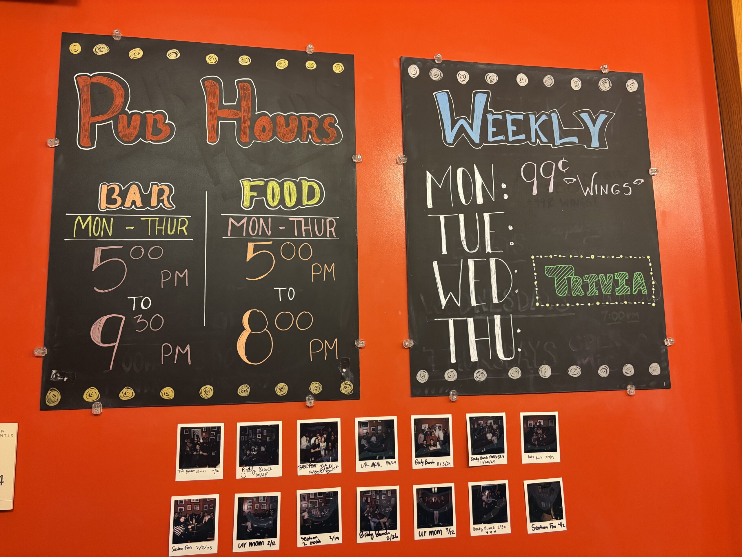 Two signs showing scheduling information for the HLS Pub. The first reads: "Pub Hours; Bar, Mon-Thurs, 5:00PM-9:30PM; Food, Mon-Thurs 5:00PM-8:00PM" The second reads: "Weekly, Monday-99 cent wings; Tuesday-blank; Wednesday-Trivia; Thursday-Blank" Below are pictures of various trivia teams.