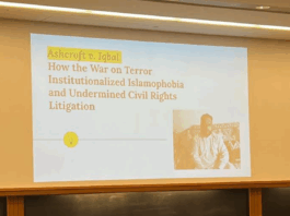 Presentation in a classroom in a Wasserstein hall section classroom reads "Ashcroft v. Iqbal: How the War on Terror Institutionalized Islamophobia and Undermined Civil Rights Litigation" (I. Bharmal, 2022).