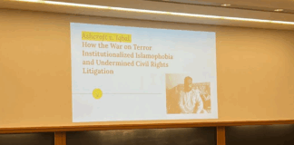 Presentation in a classroom in a Wasserstein hall section classroom reads "Ashcroft v. Iqbal: How the War on Terror Institutionalized Islamophobia and Undermined Civil Rights Litigation" (I. Bharmal, 2022).